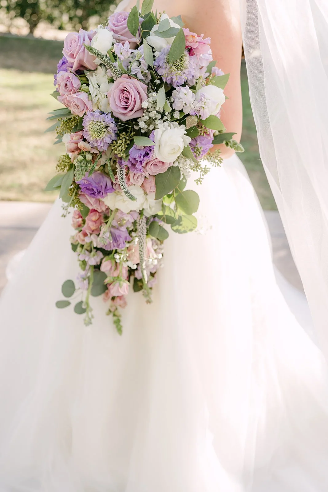 Close detail of Kate's cascading bouquet of lilac roses and white blooms.