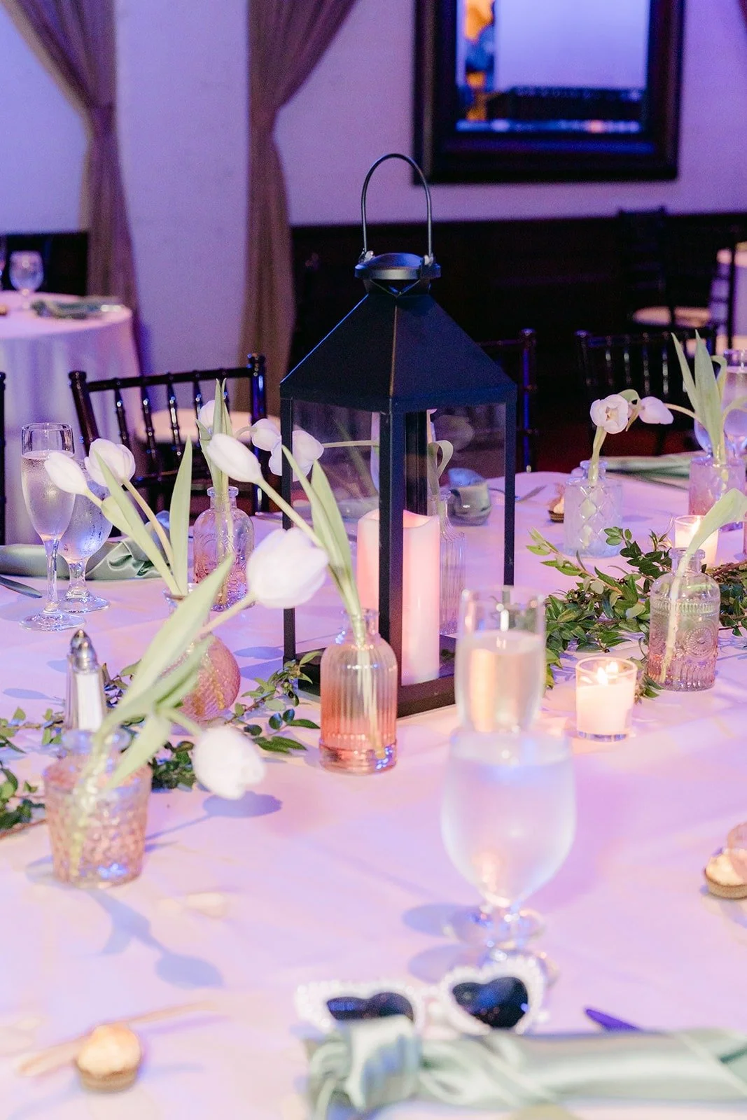Black lanterns and white tulips on a reception table