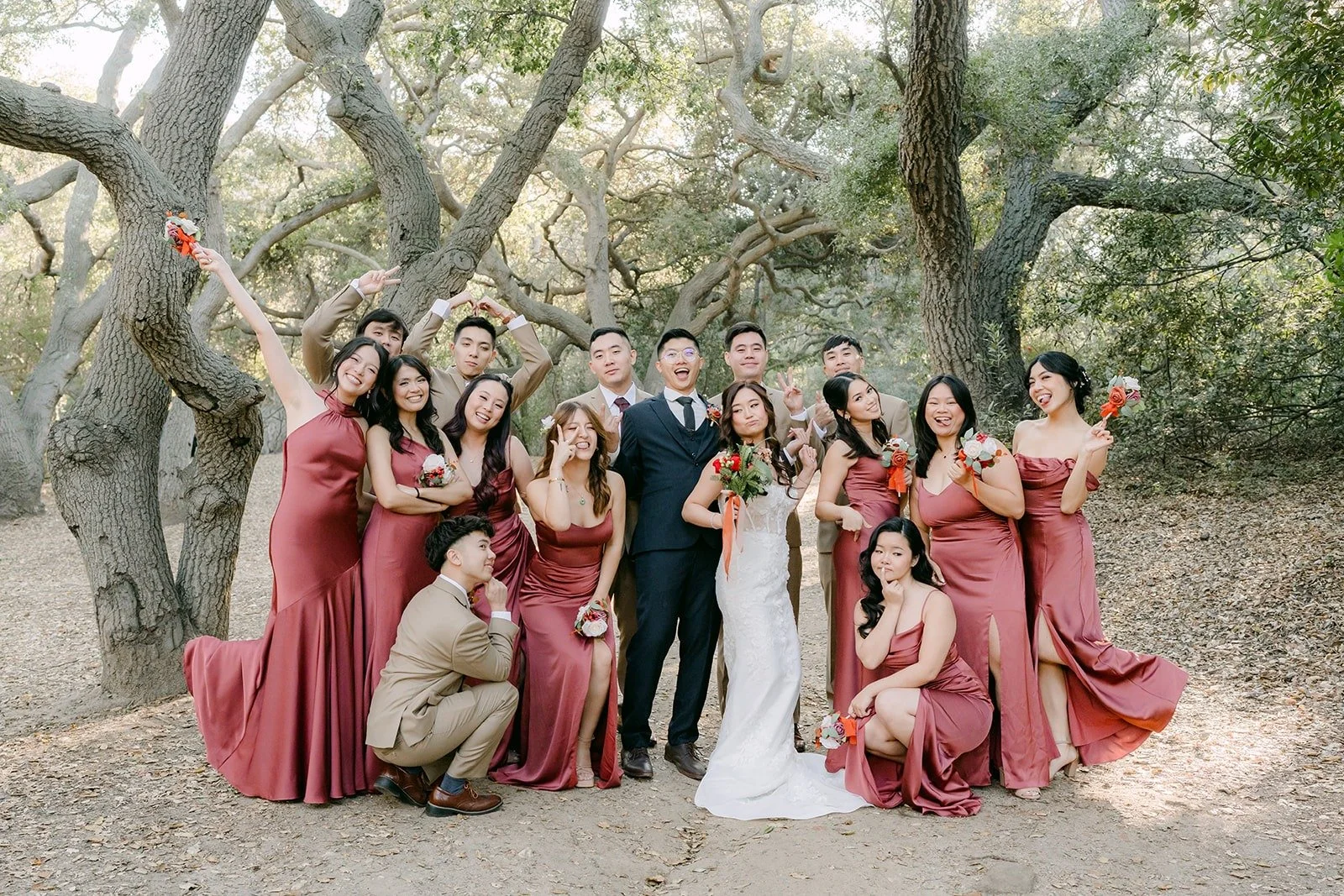 Wide view of the wedding party beneath the oak branches, photographed by One and Only Production