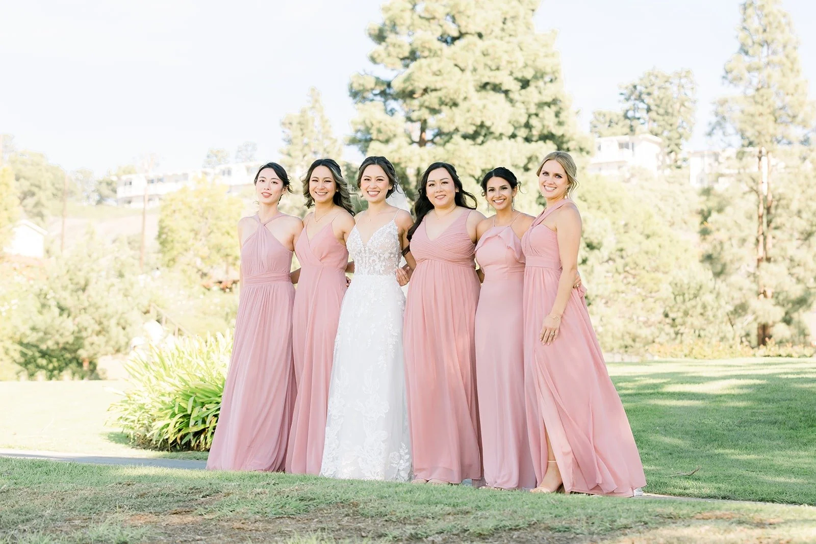 Josephine and her bridesmaids in blush pink gowns on the golf course
