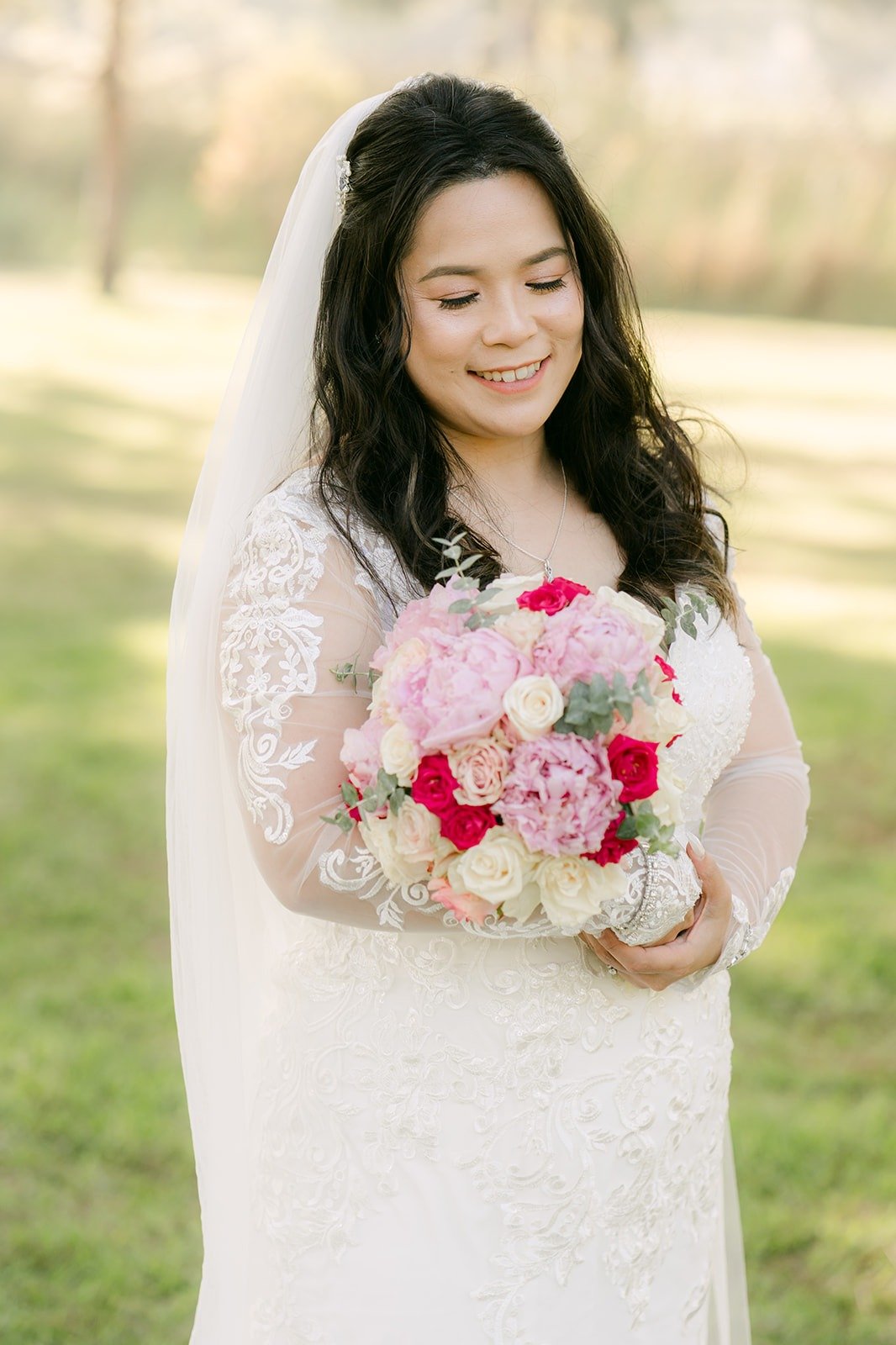 Amy smiling with her pink and white rose bouquet