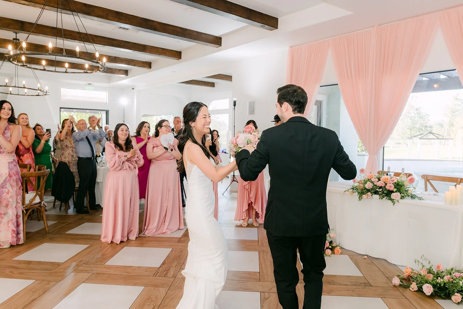 Stephanie and Kevin waving to guests as they enter the reception