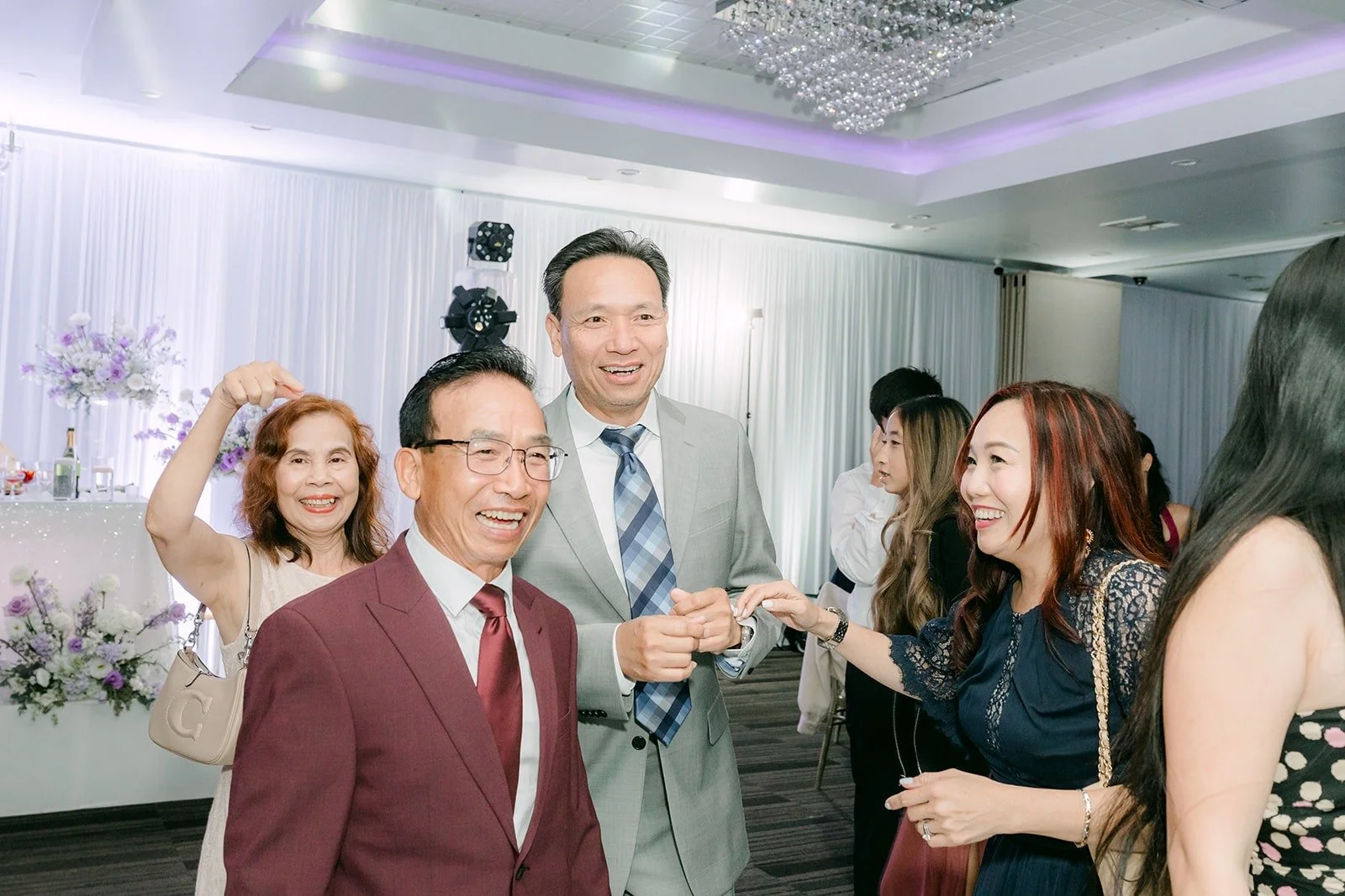 Family members dance and laugh together on the dance floor
