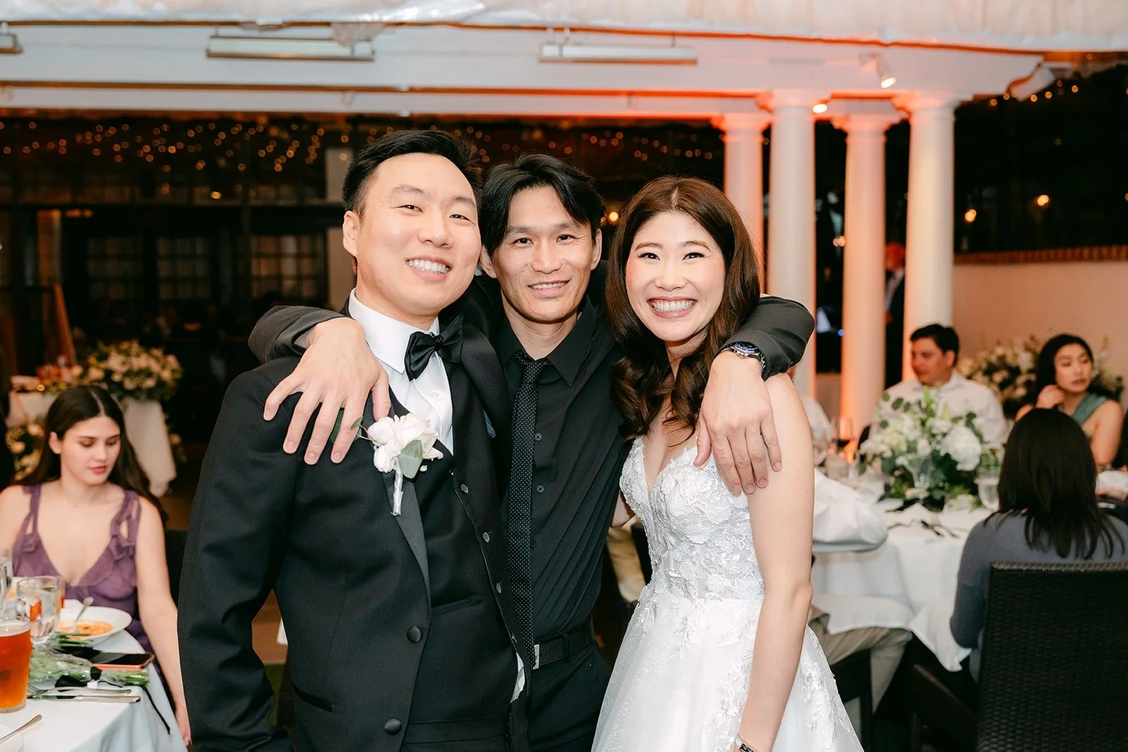 Valerie and Jason posing with a friend between tables