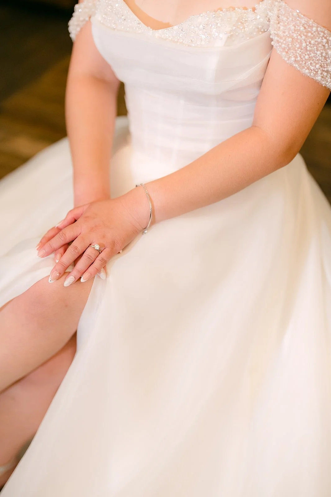A close detail of Jessica's beaded gown and ring