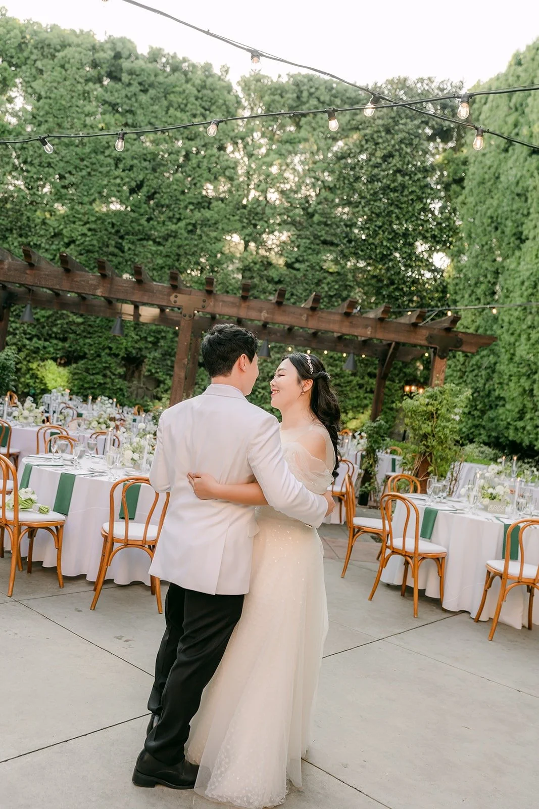 Chorok and Min Soo slow dancing among the reception tables at Franciscan Gardens