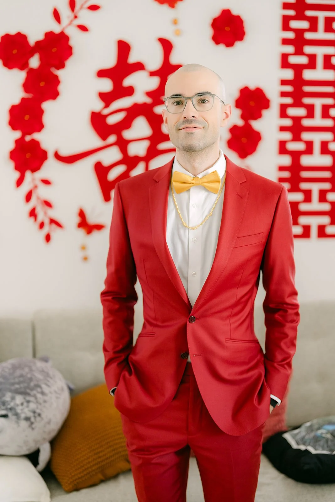 Christian in his red suit under the double happiness decorations at his family home.