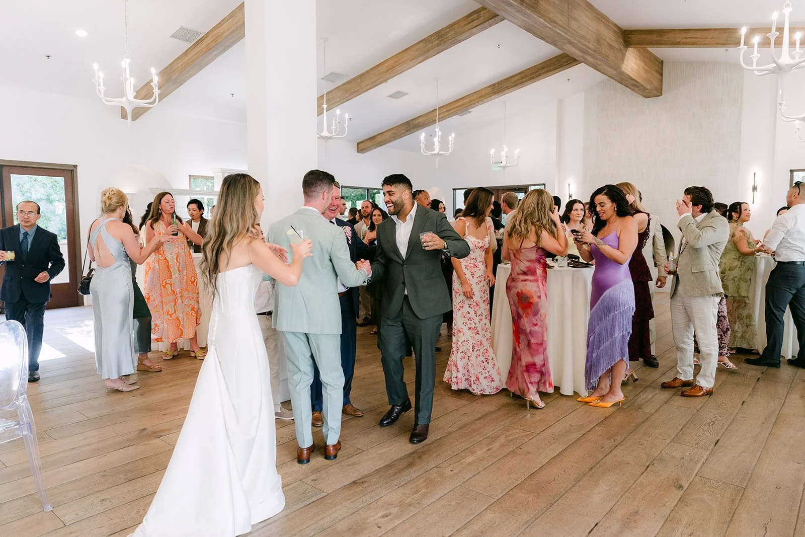 Kieu and Anthony greeting guests on the wood floor of the Lounge