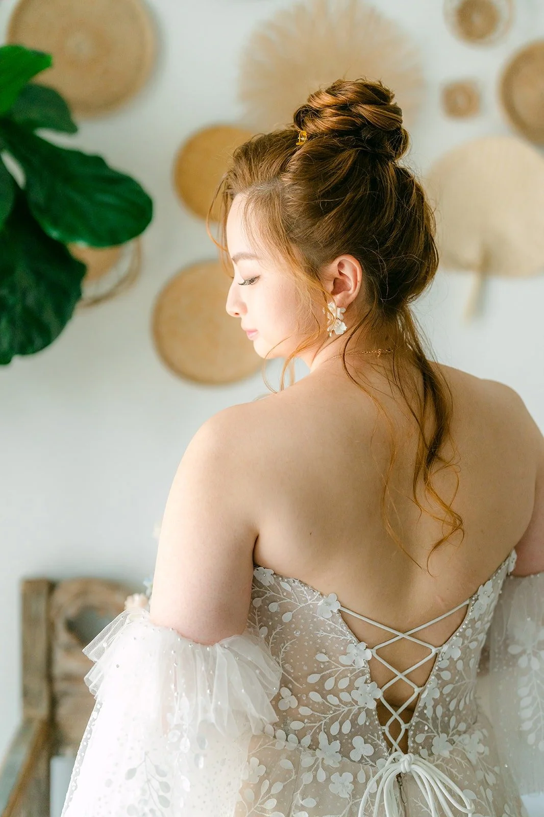 Close up of the corset lace up back of Joanna's gown and her braided updo