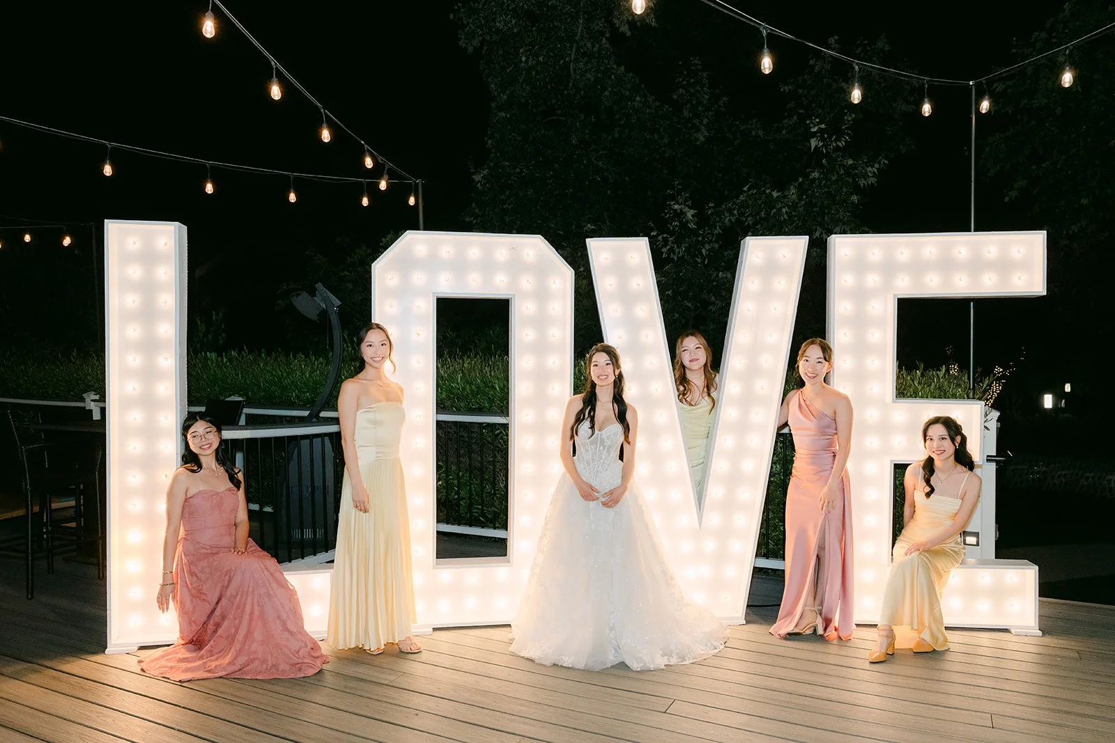Clarissa and her bridesmaids with the LOVE marquee letters, photographed by One and Only Production