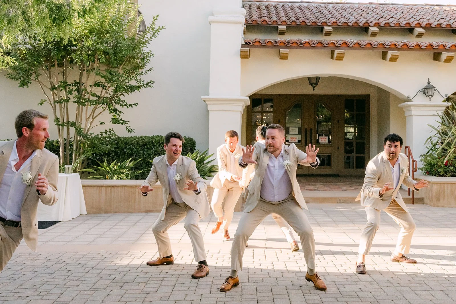 Groomsmen dancing across the courtyard for the grand entrance