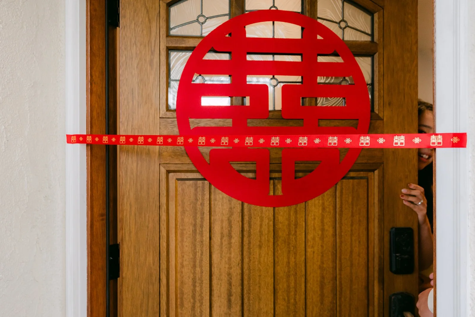 A red ribbon and double happiness sign blocking the bride's door.