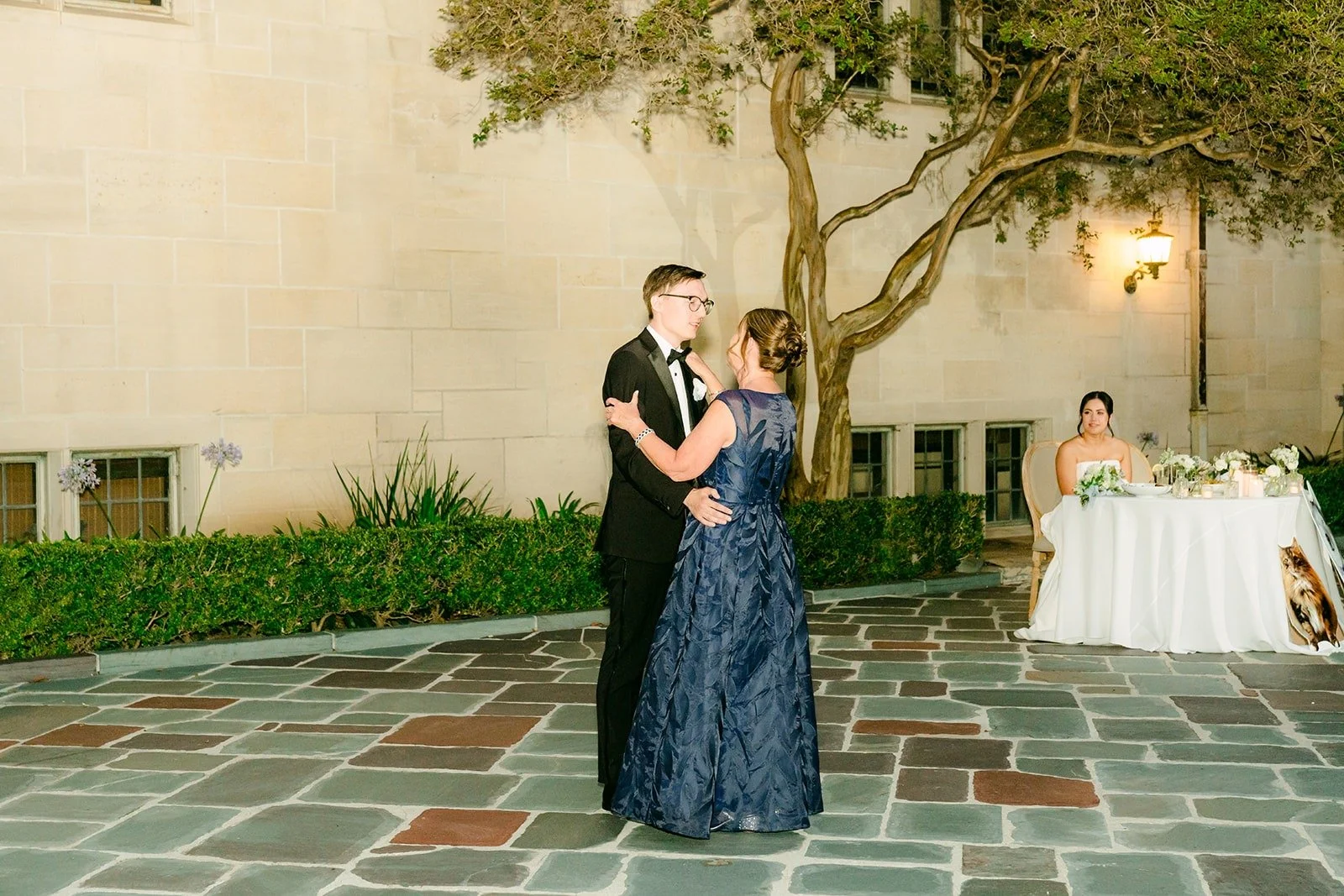 Nik and his mom sharing a dance under the courtyard lights