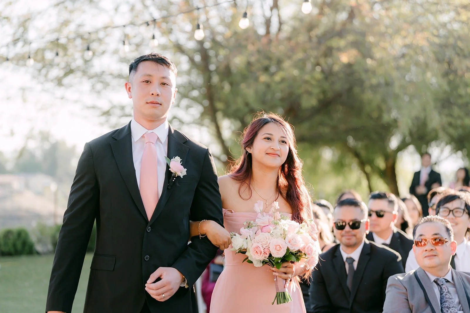 A groomsman and bridesmaid walking in together
