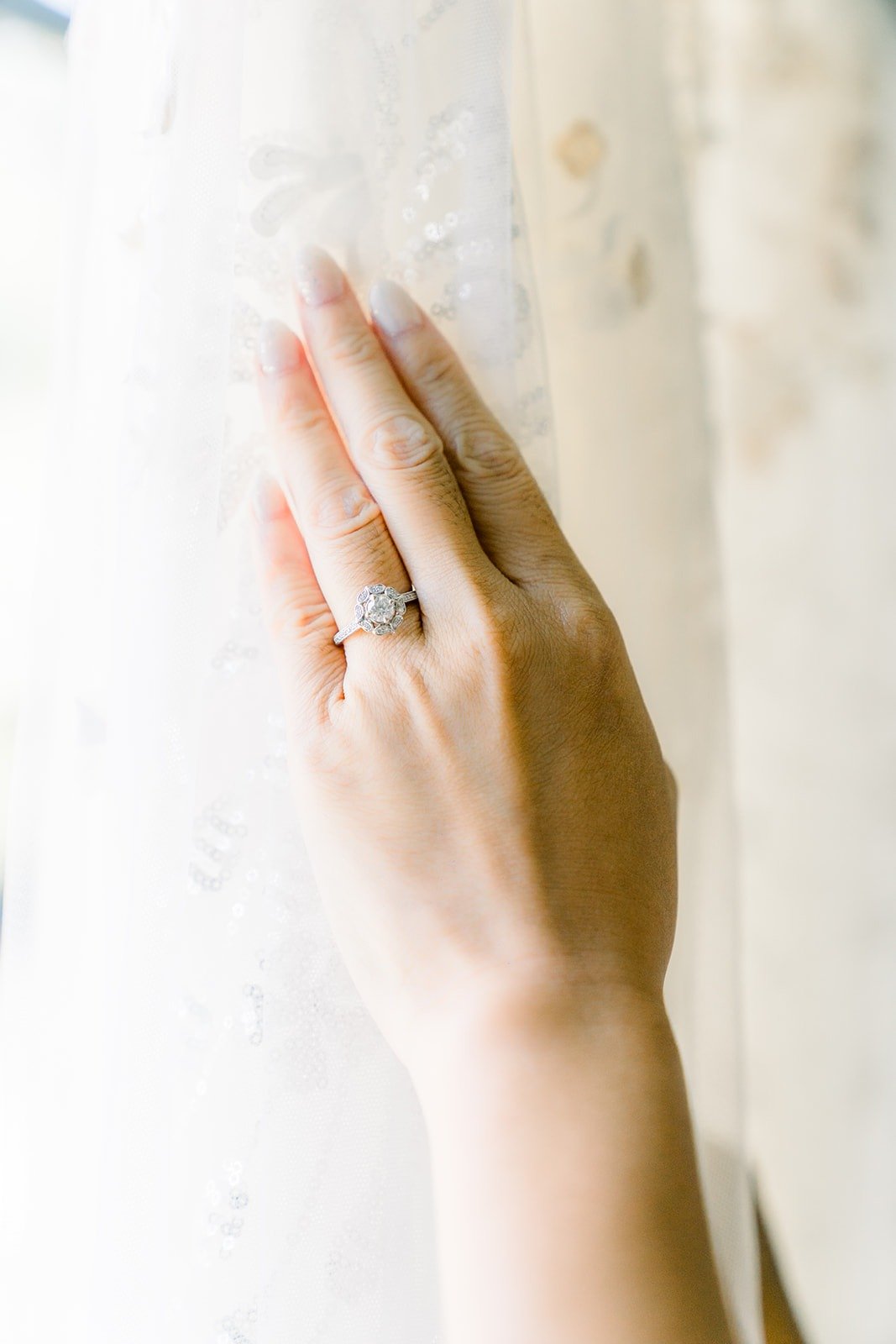 Ariel's hand and engagement ring against the lace curtain