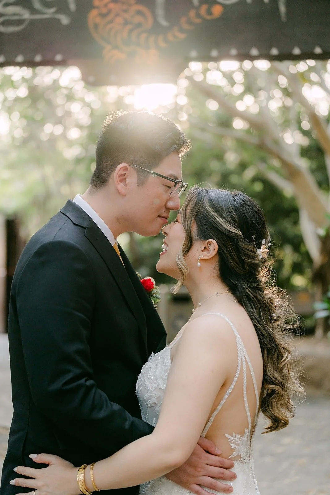 Joanne and Zach close together under the thatched roof in the late afternoon light