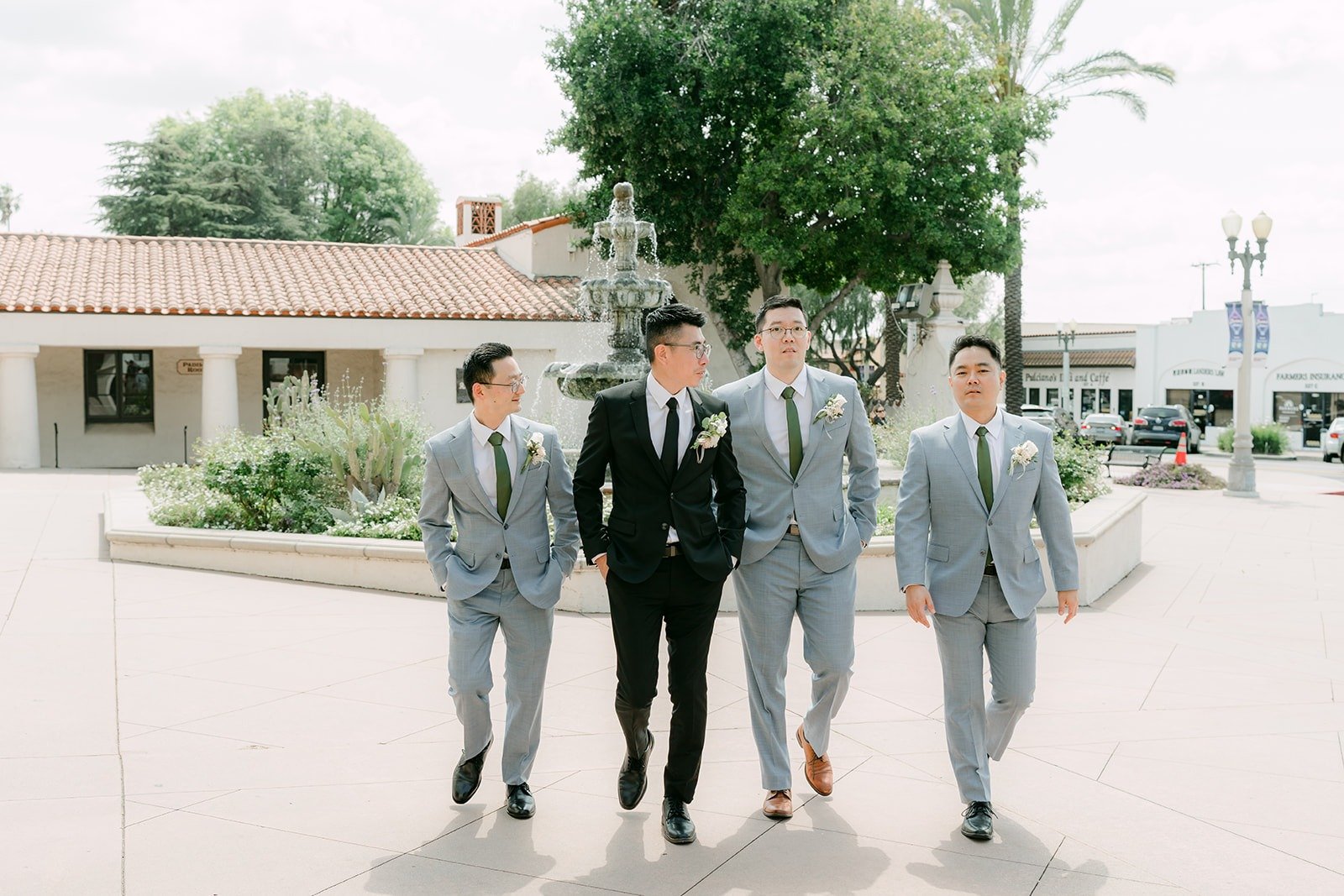 Eric and his groomsmen walk across the plaza at San Gabriel Mission