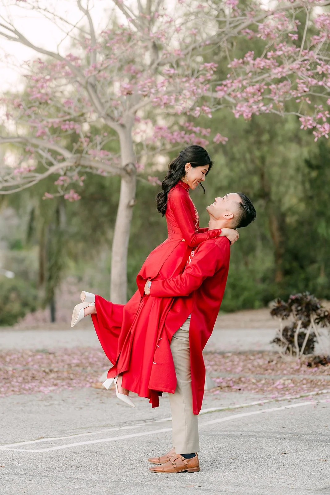 Vincent lifts Kim as the panels of her red ao dai fly.