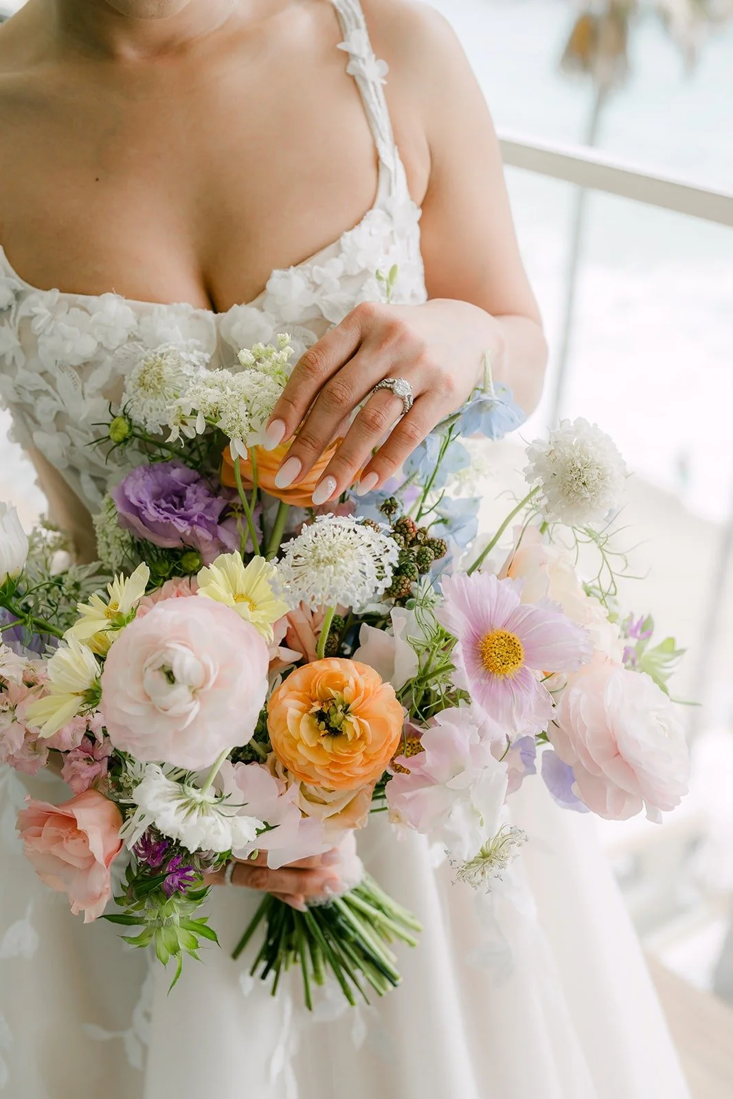 Kylie holding her pastel bouquet of peach, lavender and blush flowers