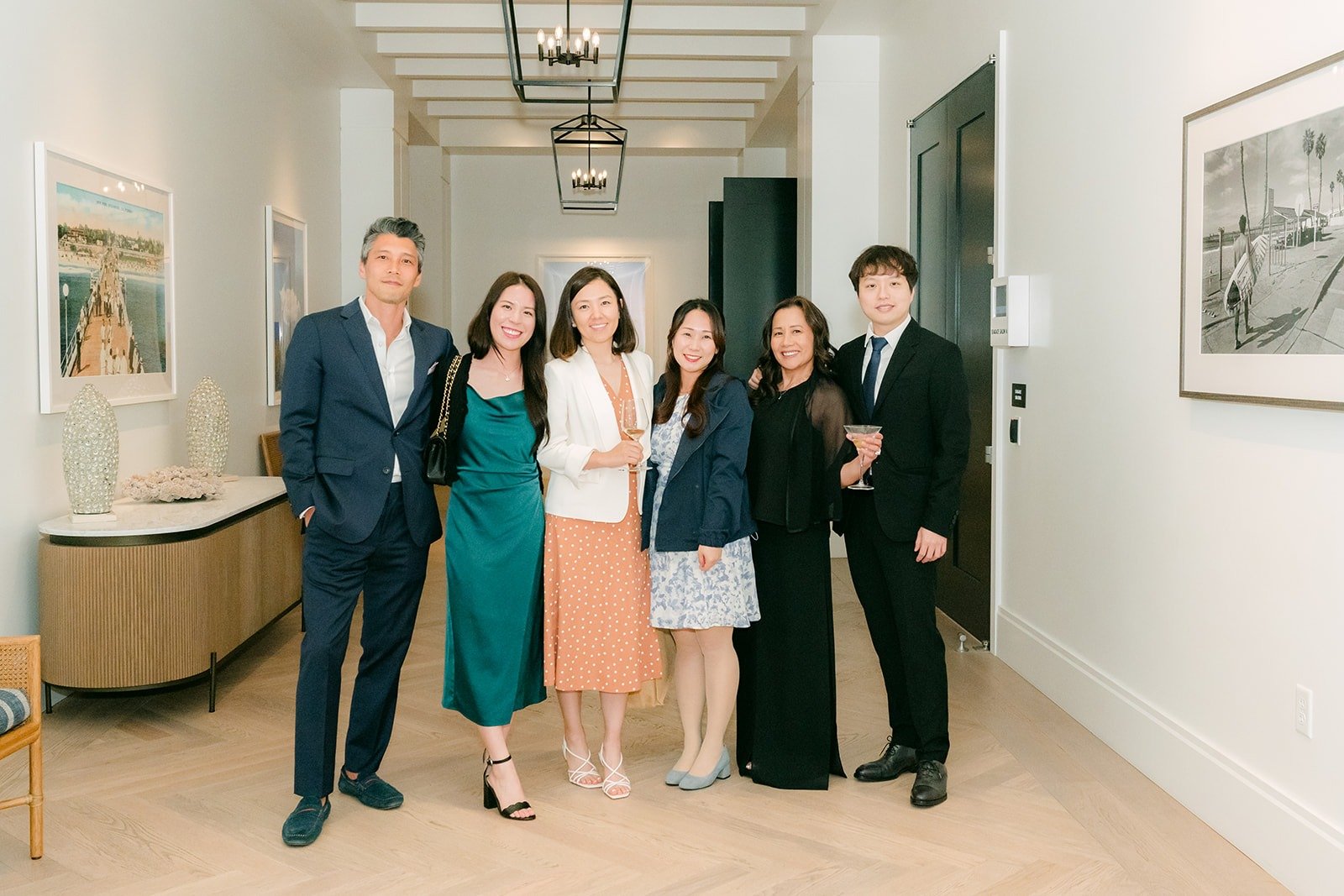 Angela and Eli posing with friends in the hallway during cocktail hour