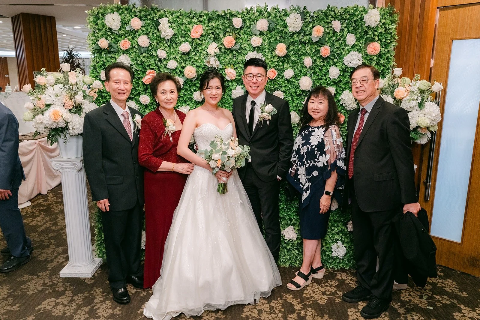 Eunice and Eric greet family at the flower wall at Five Star Seafood Restaurant
