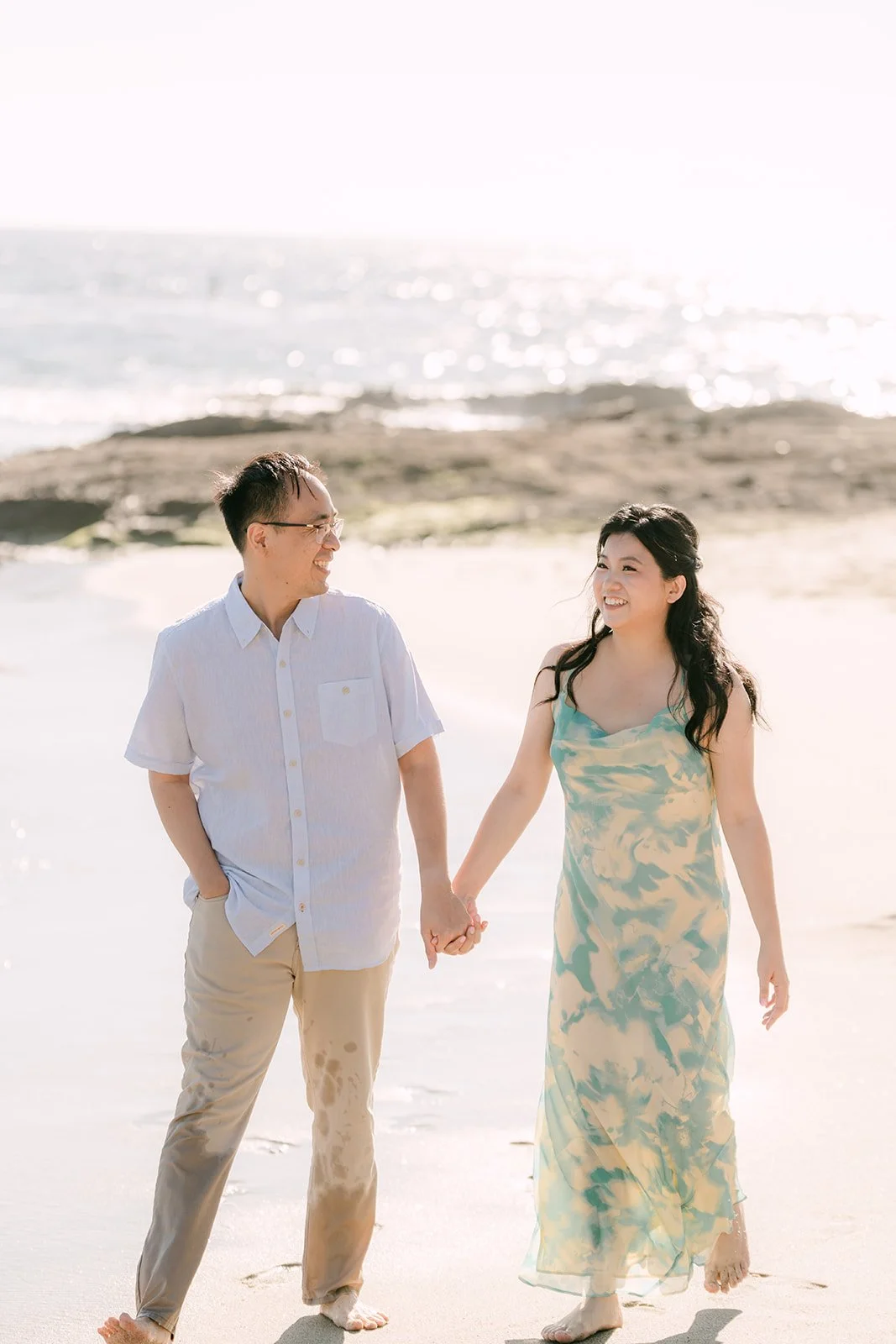 Constance and Lawrence holding hands on the shoreline.