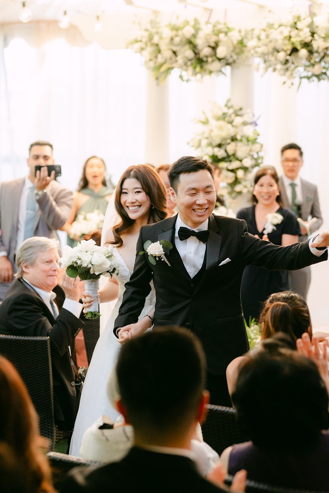 Jason cheering as he and Valerie head back up the aisle