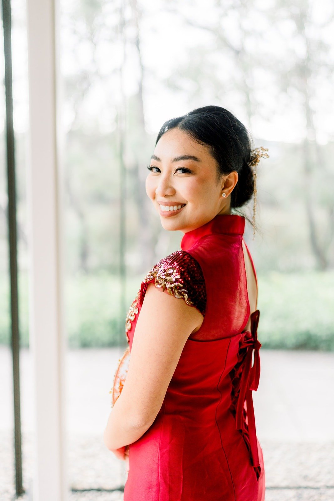 Jacinda looks back over her shoulder in her red dress