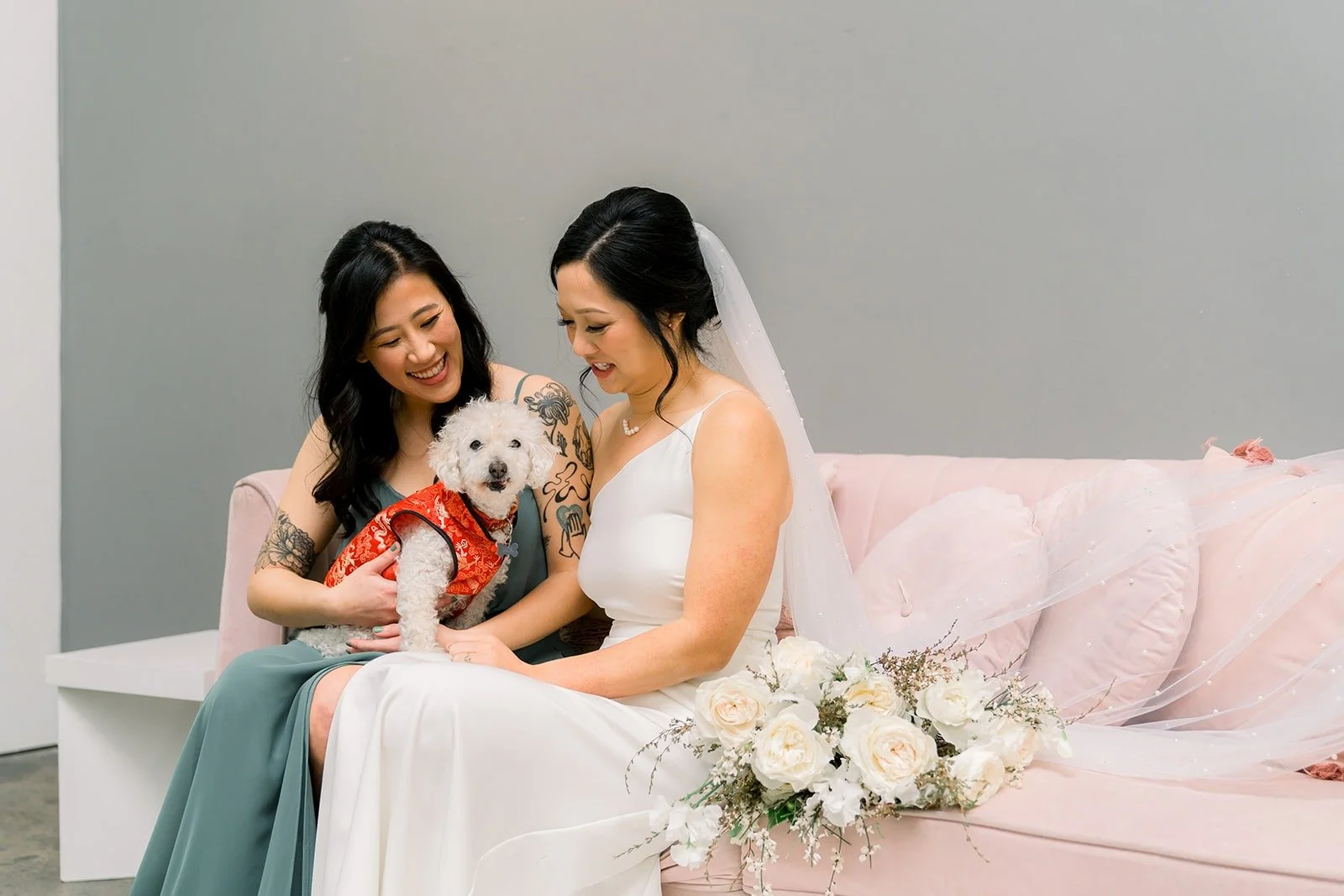Cindy and a bridesmaid share a moment on the pink sofa