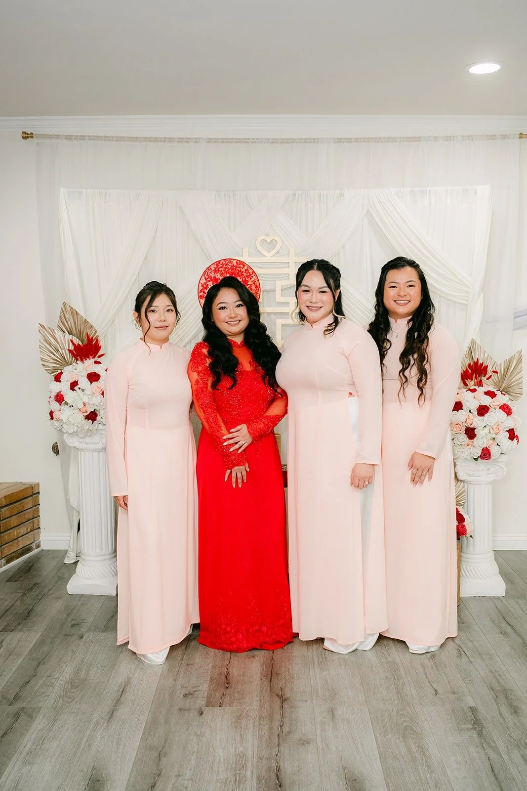 Jennifer in red with her bridesmaids in pale pink ao dai