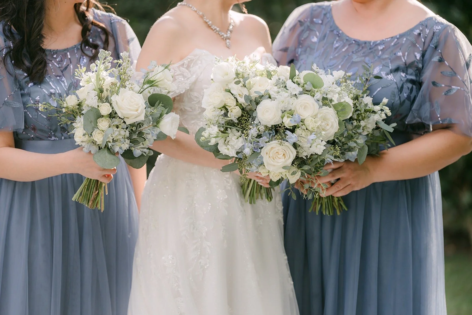 Sochi's white bouquet beside her bridesmaids in dusty blue