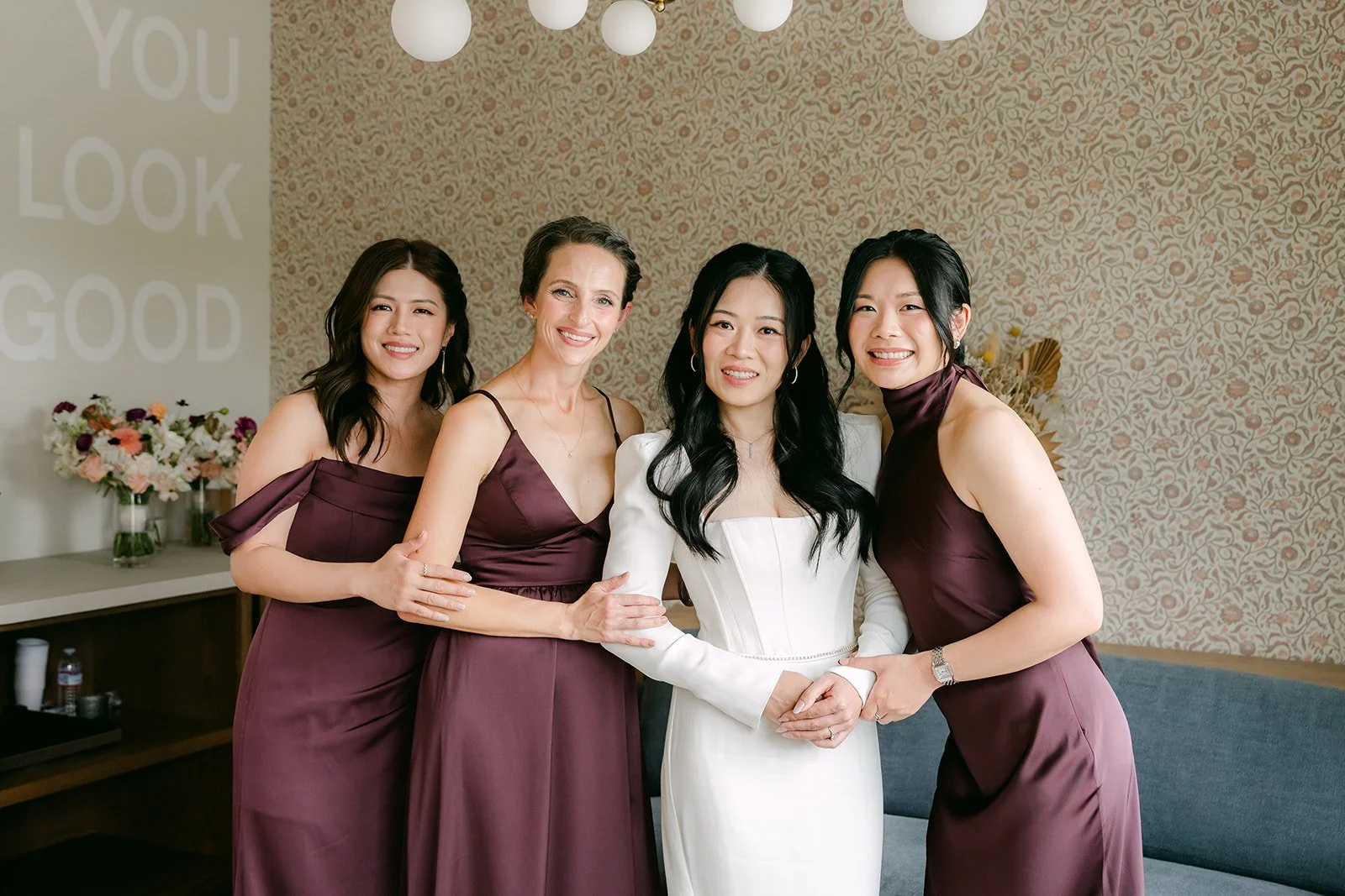 Denise laughing in a group hug with her bridesmaids.
