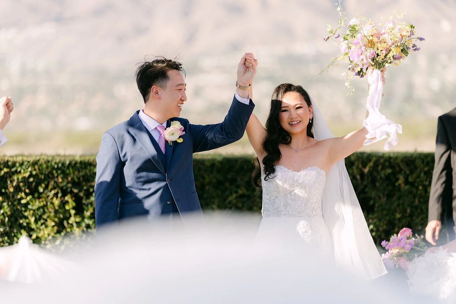 Vannie raising her bouquet as she and Elijah celebrate.