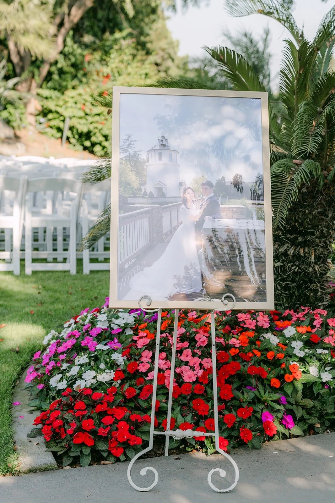 A welcome sign with Jeannie and Eunsang's photo on an easel above red flowers