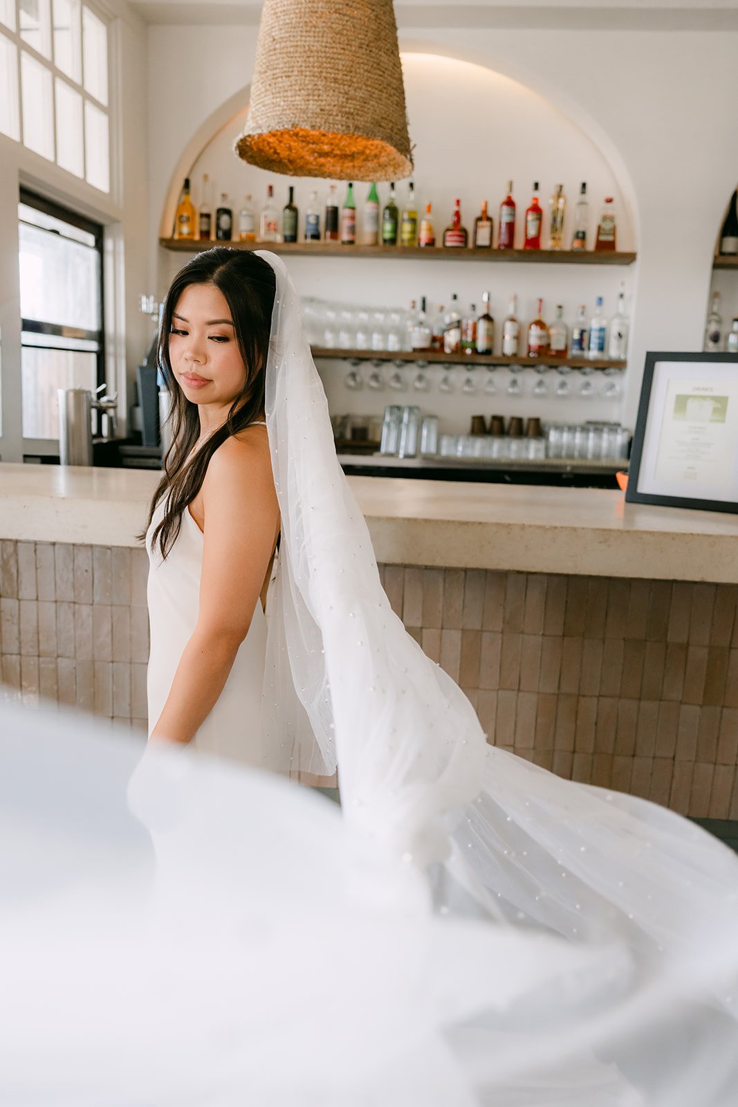 Justine at the bar with her veil spread out
