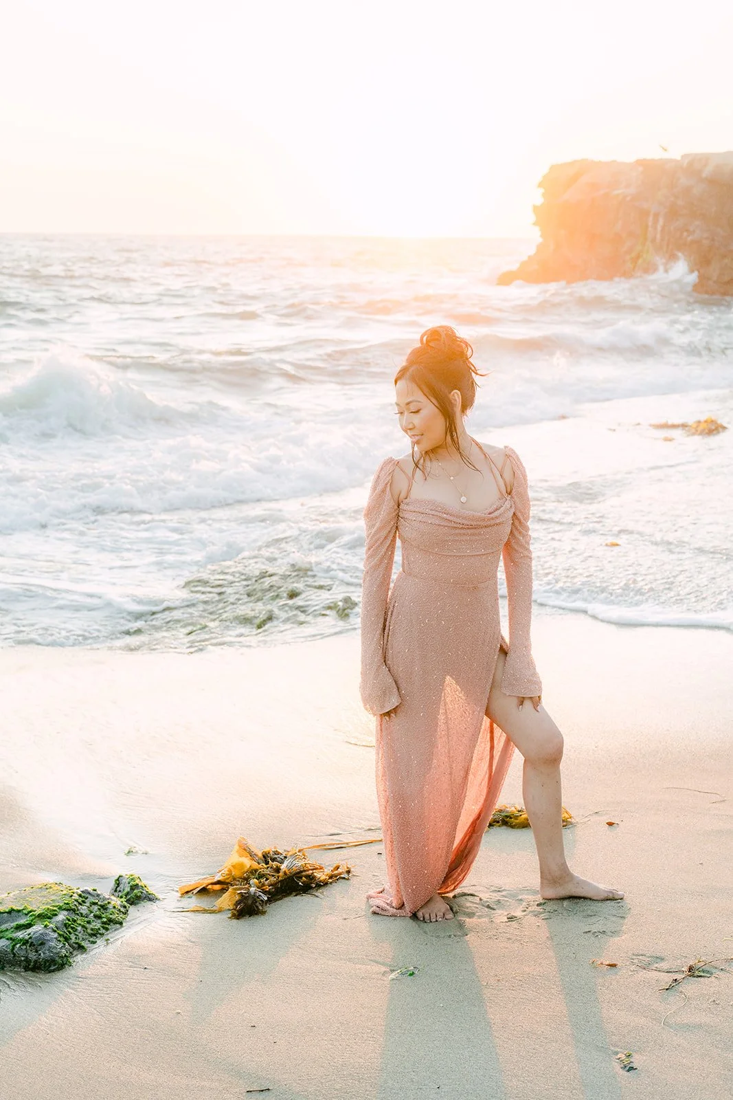 Amy standing at the water's edge in golden light.