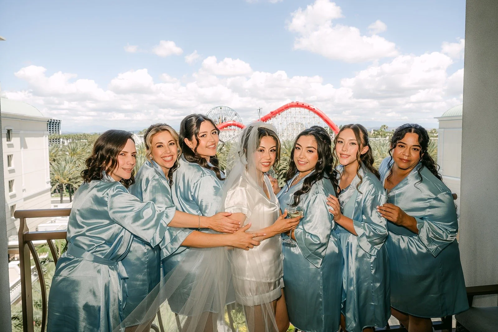 The bridesmaids gather around Francesca on the balcony for a laughing group photo