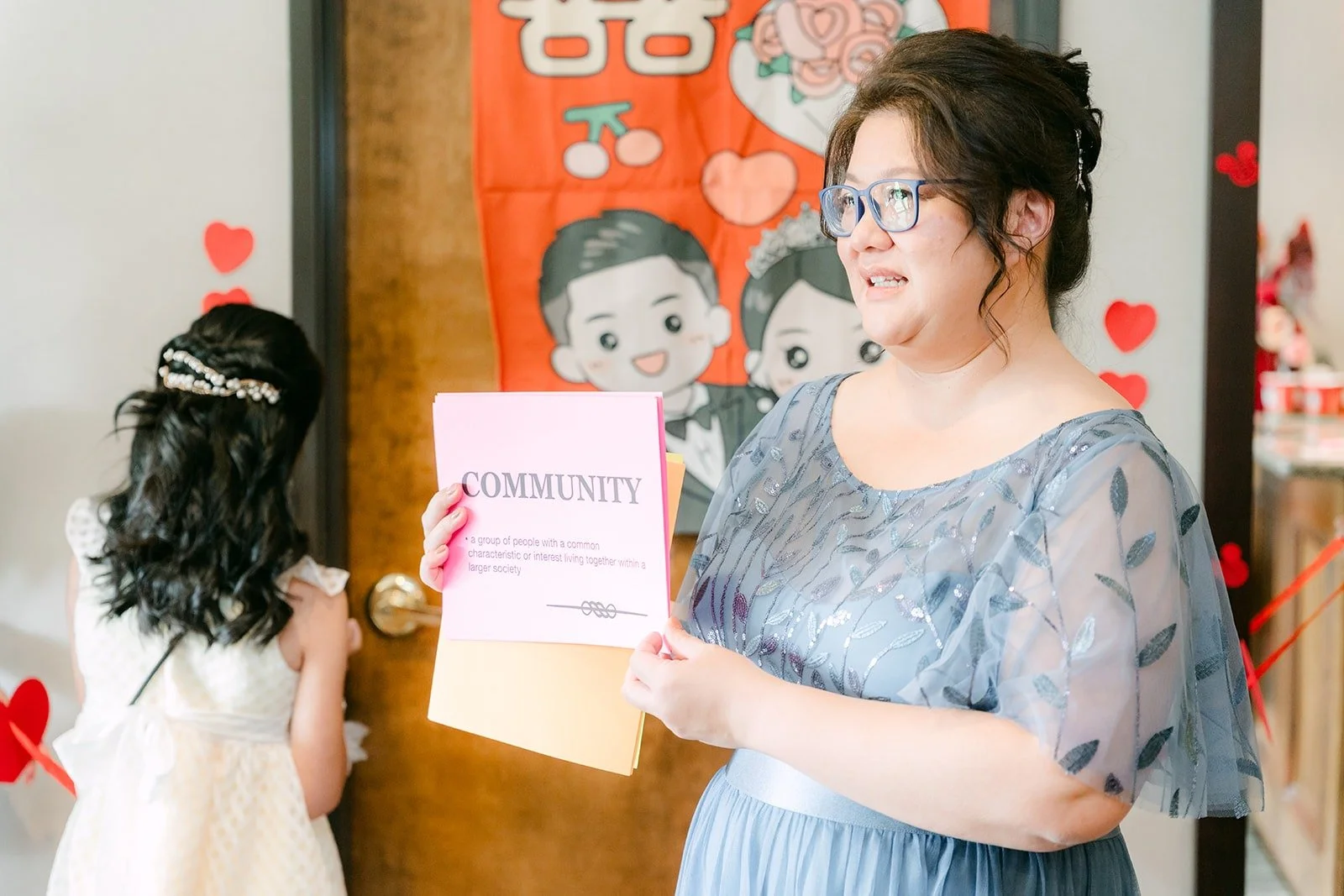 A bridesmaid reads out a door game challenge from a pink card
