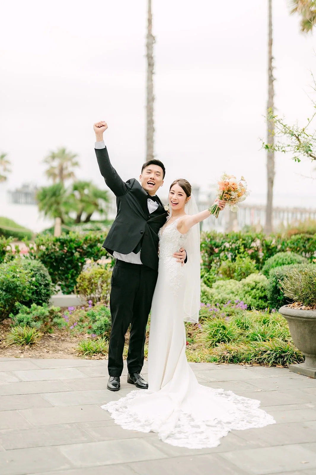 Eli cheering with his fist in the air as Angela laughs beside him