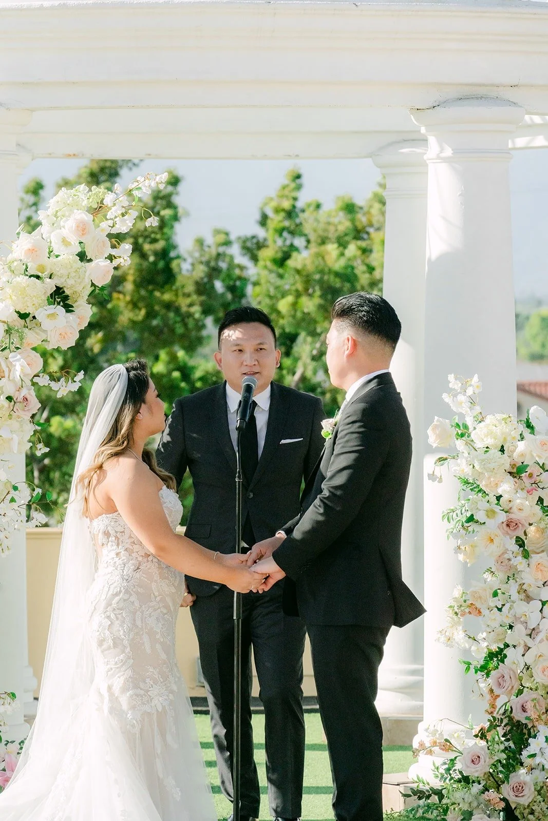 Candice and Vincent holding hands as Douglas leads the ceremony