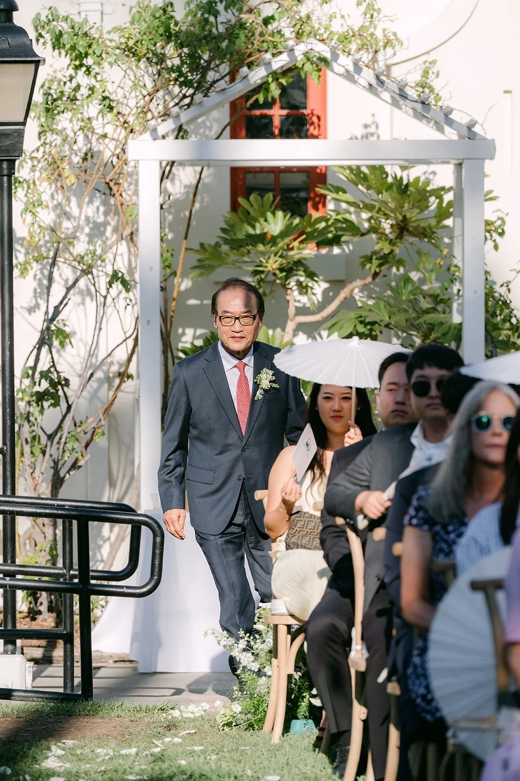 A family member walking down the aisle under the arbor