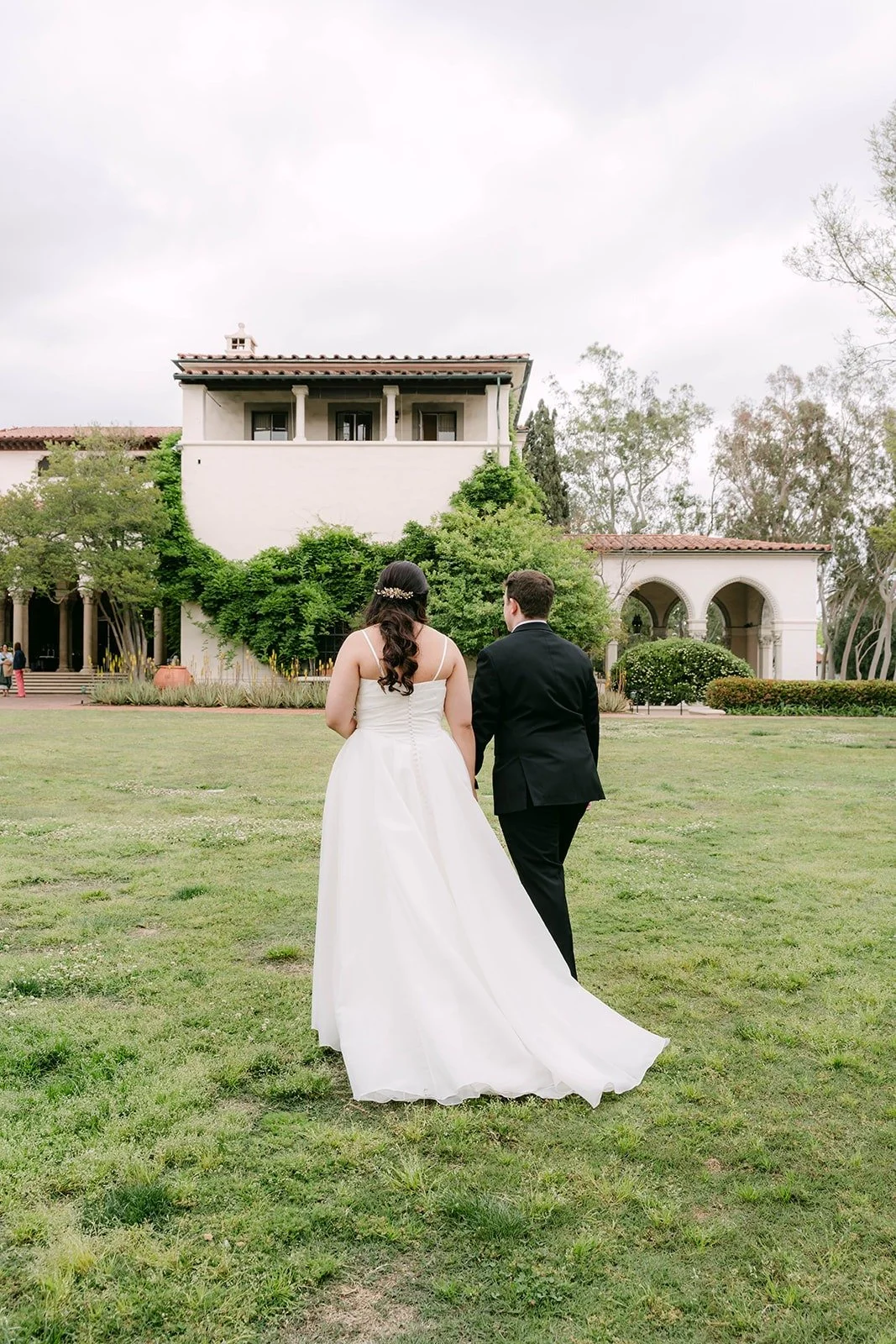 Saira and Matthew walking across the Athenaeum lawn toward the building