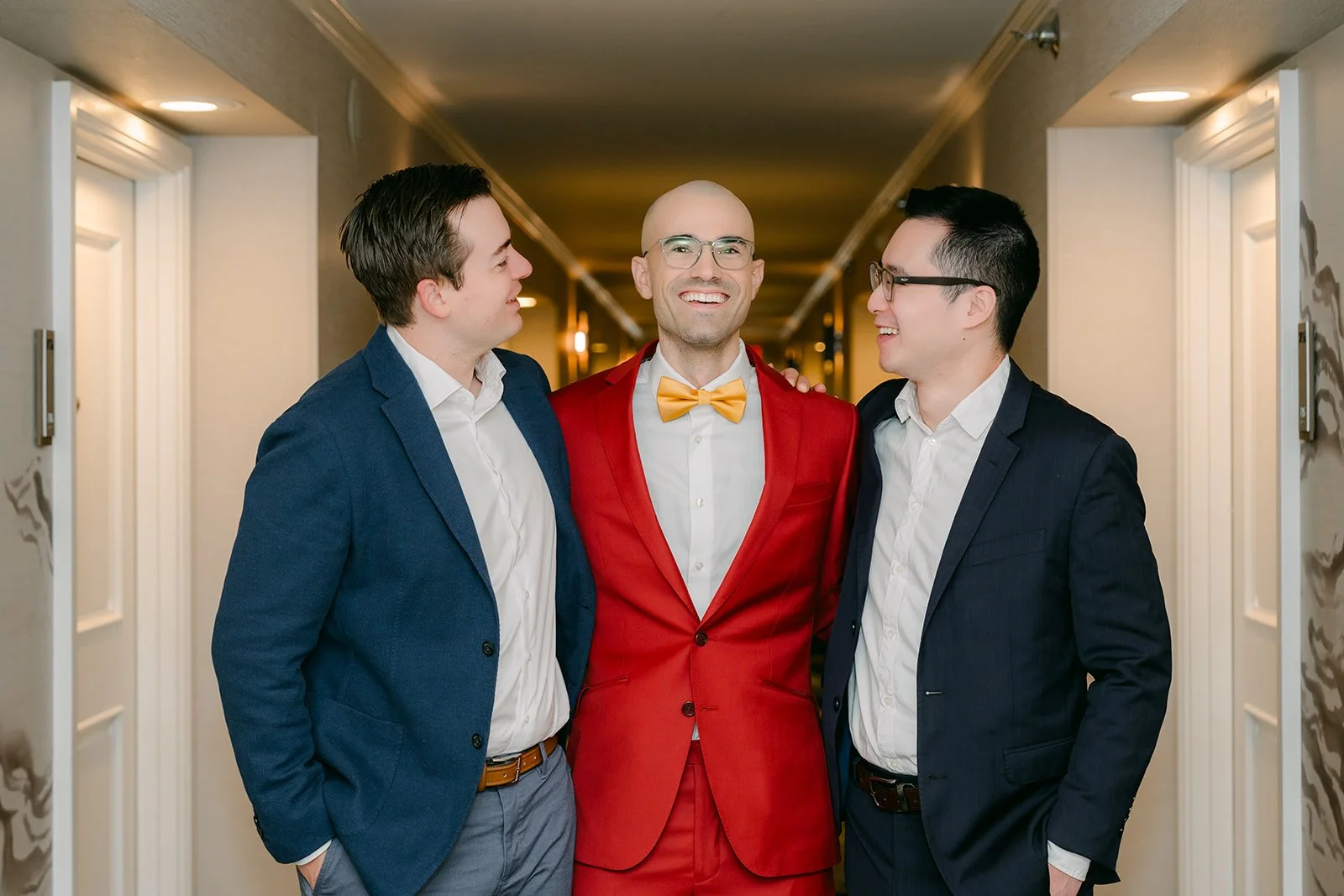 Christian in his red suit with friends Ivan and Tyler in the hotel hallway before the door game.