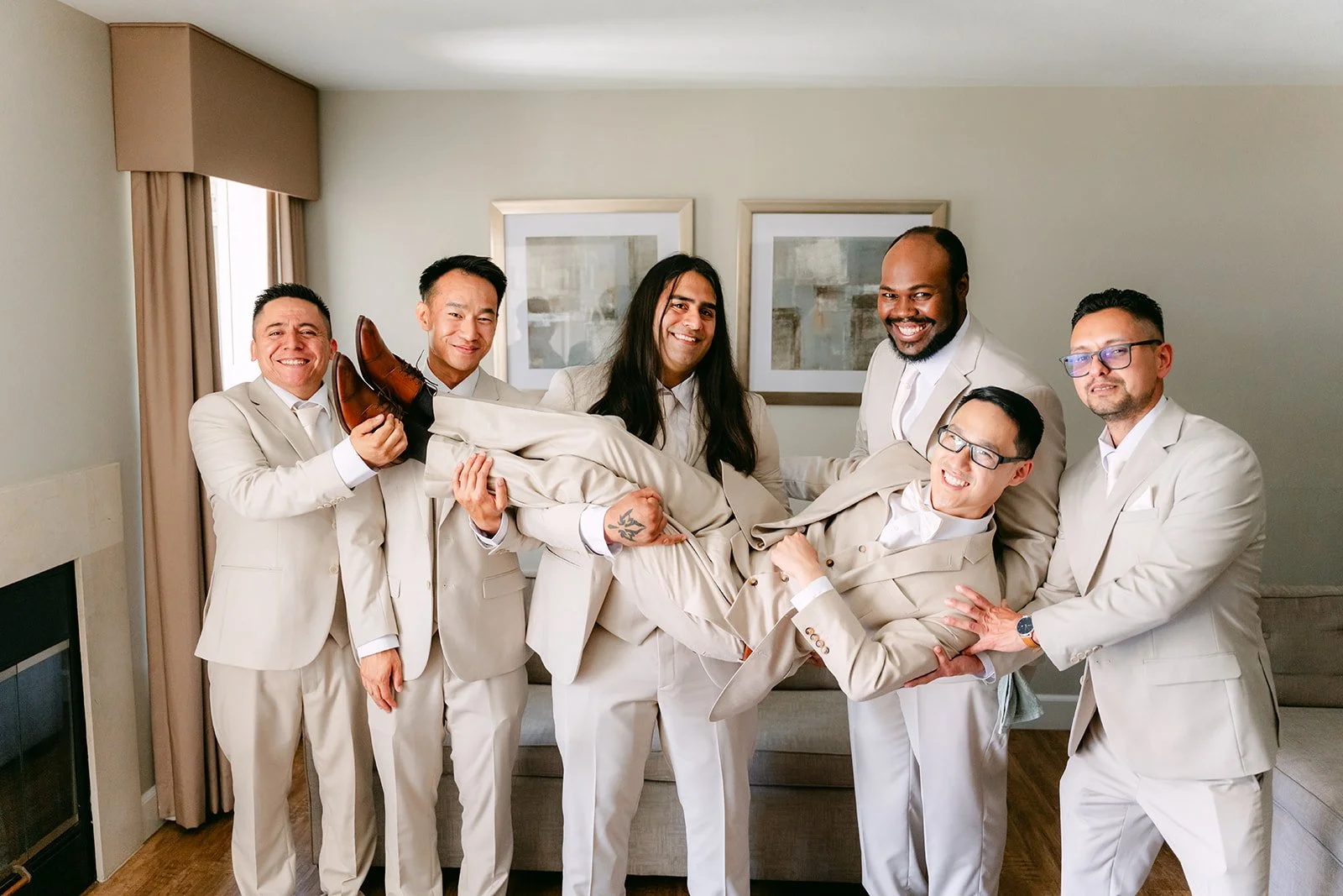 Kevin and his groomsmen in champagne suits goofing around before the ceremony.