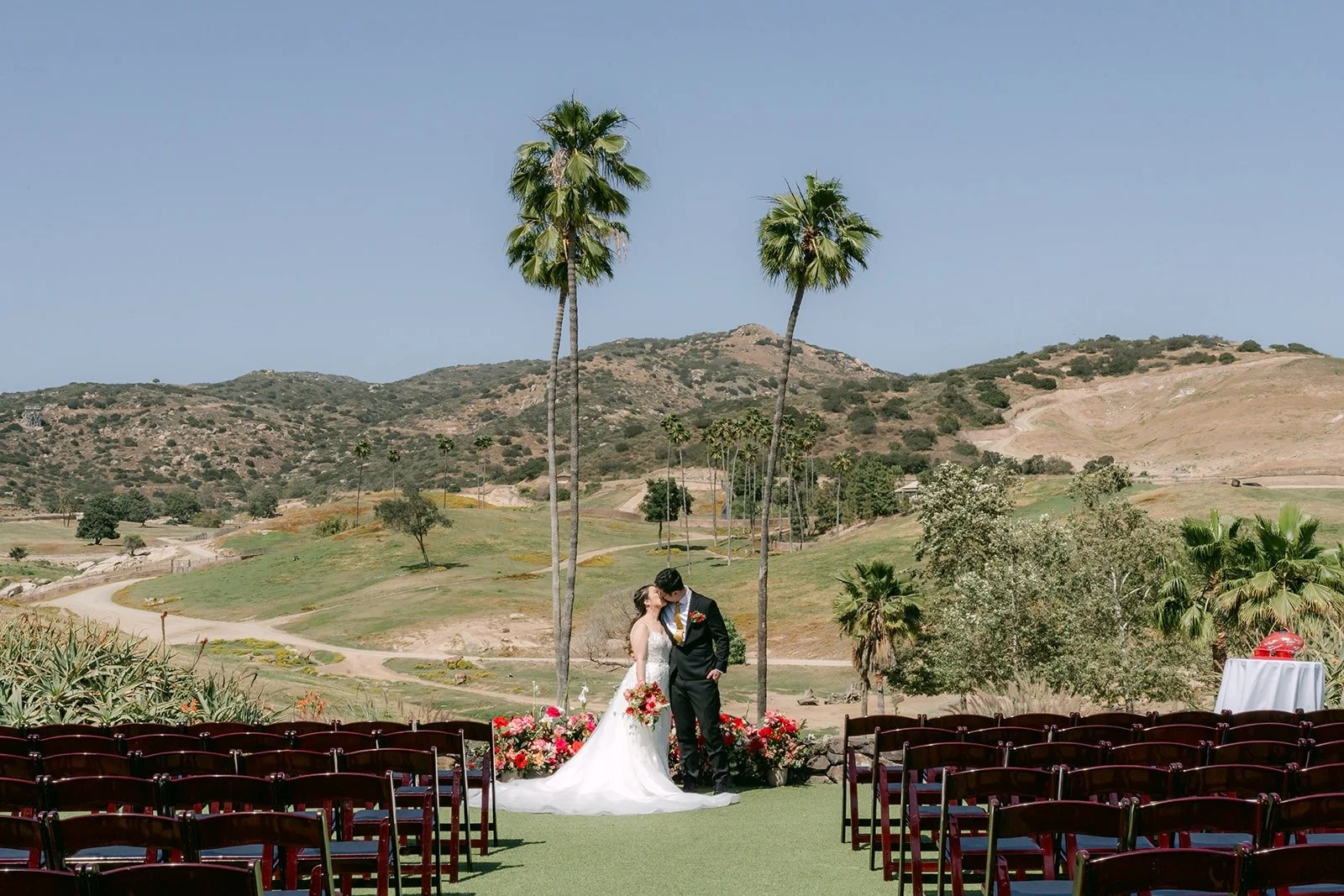 Joanne and Zach between the rows of ceremony chairs at Kijamii Overlook
