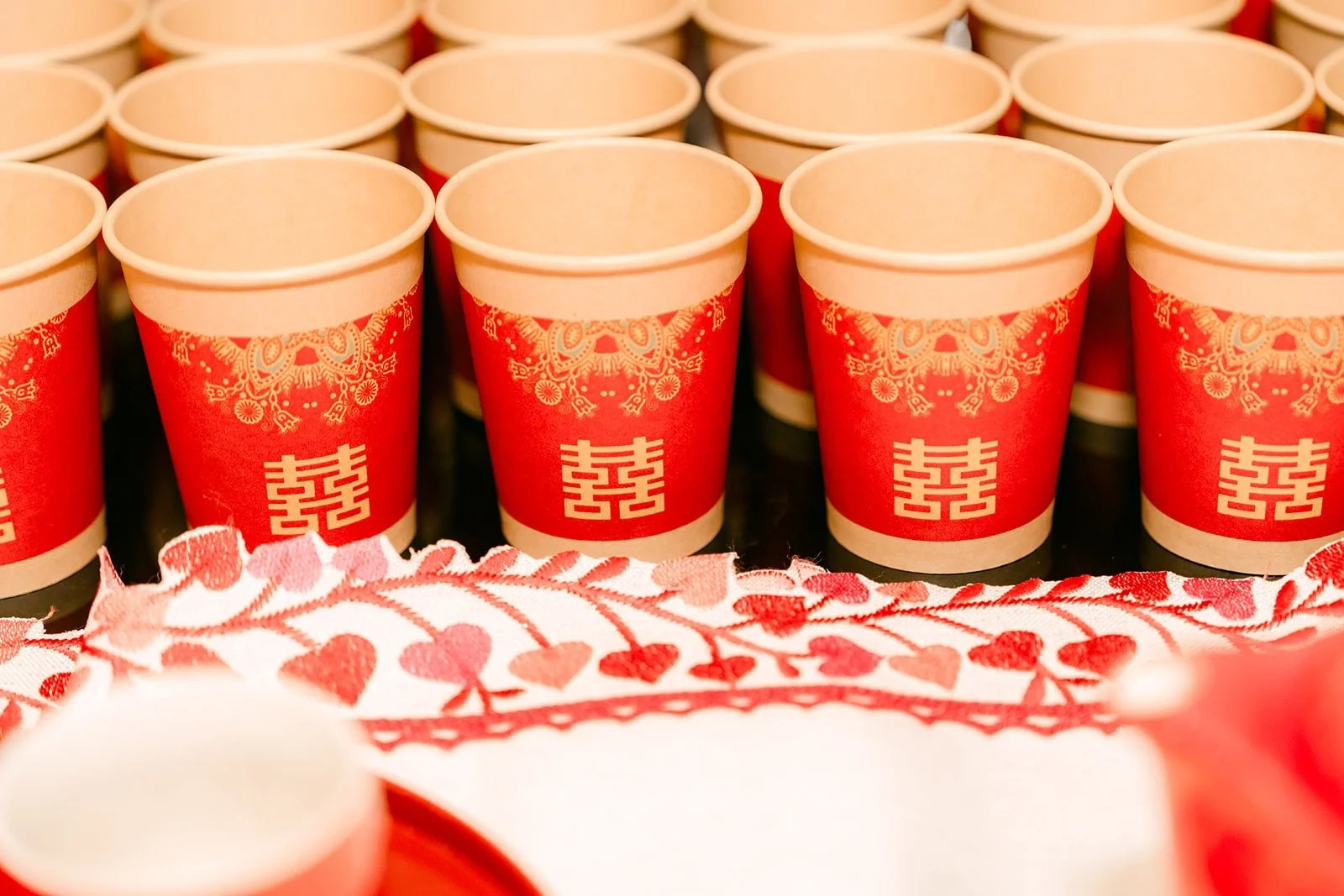 Rows of red paper cups printed with the double happiness symbol for the tea ceremony