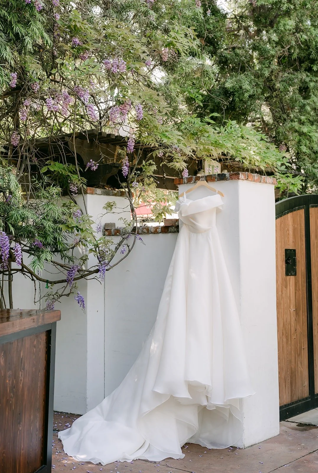 Chorok's white wedding gown hanging outdoors under green vines