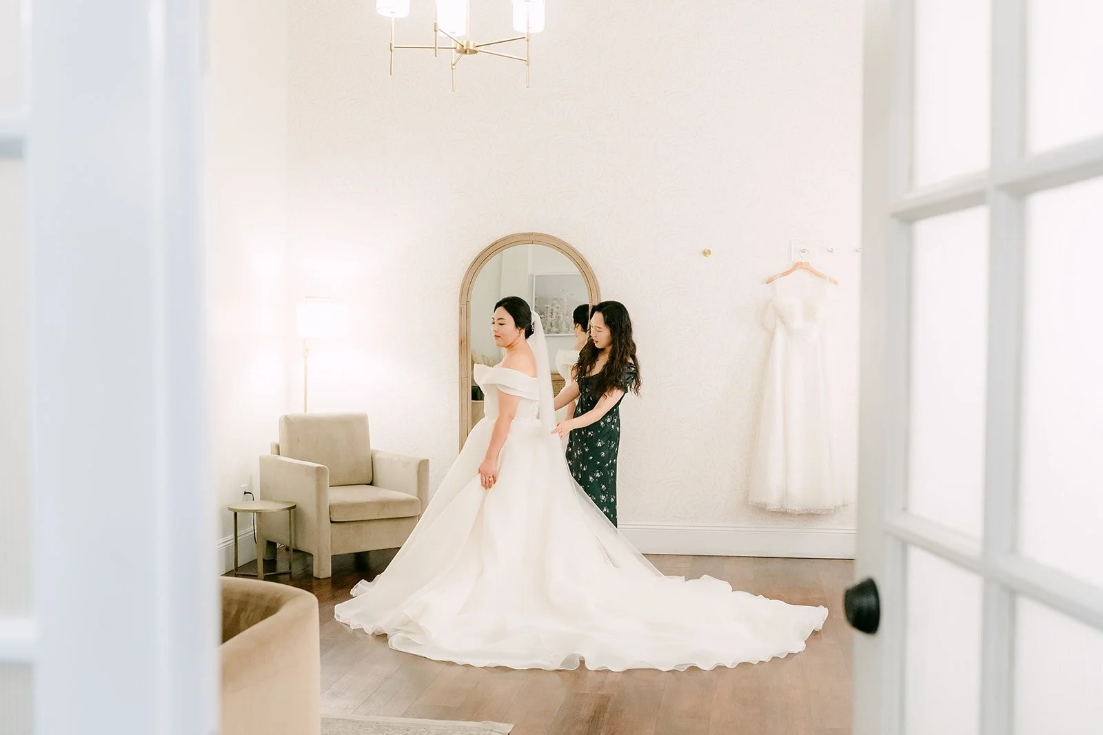 Chorok in her gown in the bright white getting ready suite, photographed by One and Only Production