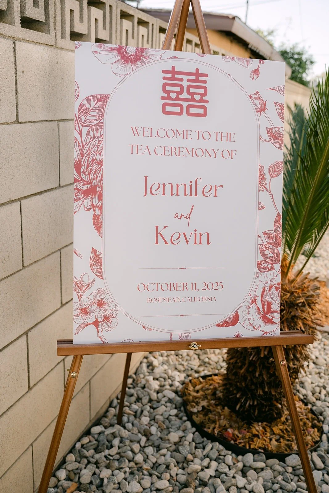 A white and red welcome sign for Jennifer and Kevin's tea ceremony on an easel outside the house