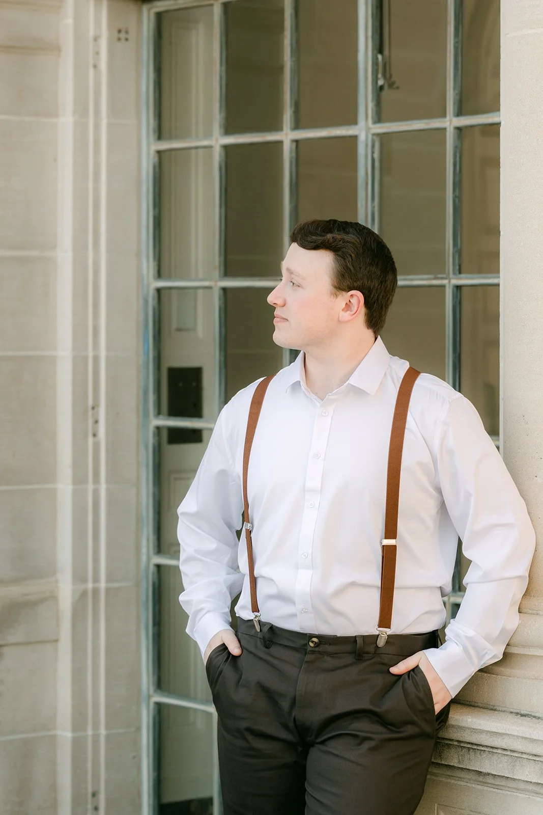 Matthew leaning against the mansion's leaded glass windows.